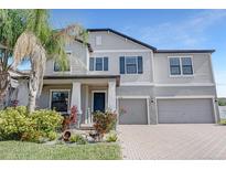 Beautiful two-story home featuring a three-car garage, landscaped yard, and a welcoming front porch at 11726 Sunburst Marble Rd, Riverview, FL 33579