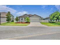 Charming single-story home with well-maintained landscaping, a paved driveway, and a two-car garage at 12653 Palapa Loop, Spring Hill, FL 34610