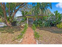 Charming single-story home with lush landscaping and a welcoming brick pathway at 1402 E Mohawk Ave, Tampa, FL 33604