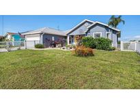 Charming single-story home featuring well-manicured lawn and lush landscaping at 2611 San Luis Rd, Holiday, FL 34691