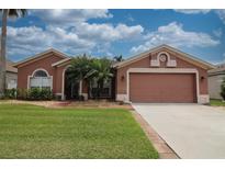 Charming single-story home with manicured lawn, brick walkway, and two-car garage at 29650 Eagle Station Dr, Wesley Chapel, FL 33543