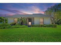 Charming single-story home with lush green lawn and well-manicured landscaping in a peaceful neighborhood at 301 Windrush Loop, Tarpon Springs, FL 34689