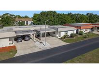 Well-maintained exterior featuring a carport, landscaped garden, and an American flag at 4039 La Pasida Ln, New Port Richey, FL 34655