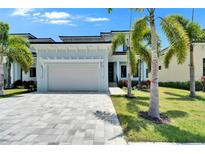 Charming single-Gathering home featuring a two-car garage, lush landscaping, and beautiful palm trees at 6530 Simone Shores Cir, Apollo Beach, FL 33572