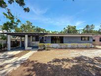 Charming single-story home featuring stone accents, a covered carport, and mature landscaping in a sunny neighborhood at 922 Alcazar S Way, St Petersburg, FL 33705