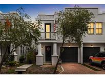 Charming townhome featuring a private entrance with a balcony, garage, and mature landscaping at 109 S Packwood Ave # B, Tampa, FL 33606