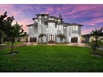 Stunning modern home with a well-manicured lawn, 3-car garage, and striking architectural design at 110 Carlyle Dr, Palm Harbor, FL 34683