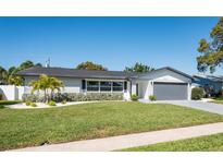 Charming single-story home featuring a brick facade, well-manicured lawn, and a two-car garage at 14261 113Th Ave, Largo, FL 33774