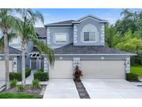 Charming townhome featuring a two-car garage and tropical landscaping at 18148 Nassau Point Dr, Tampa, FL 33647