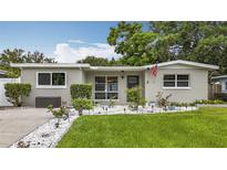 Charming single-story home with well-manicured lawn and garden pathway at 1921 Ridgewood Dr, Clearwater, FL 33763