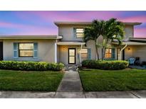 Charming home exterior with lush landscaping, blue shutters, and a welcoming walkway to the front door at 2131 Ridge S Rd # 3, Largo, FL 33778