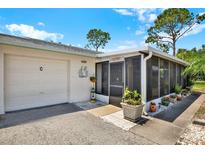Charming home featuring an attached garage, a screened-in porch, and well-maintained landscaping at 3229 40Th S Ln # C, St Petersburg, FL 33711
