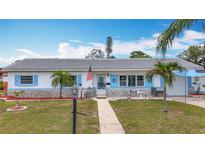 Charming single-story home with well-manicured lawn, stone accents, and beautiful blue shutters on a bright, sunny day at 6350 18Th N Ave, St Petersburg, FL 33710