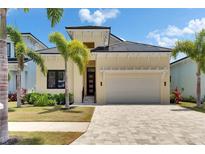 Inviting single-Gathering home features a manicured lawn, tropical landscaping, and a spacious two-car garage at 6532 Simone Shores Cir, Apollo Beach, FL 33572