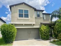 Two-story home featuring an attached two-car garage and well-maintained landscaping at 9520 Lemon Drop Loop, Sun City Center, FL 33573