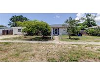 Modest single-story home featuring a charming entrance and mature trees in a tranquil front yard at 1242 Bermuda St, Clearwater, FL 33755