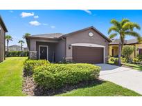 Charming single-story home featuring a well-manicured lawn and a two-car garage at 1321 Custer Bayou St, Ruskin, FL 33570