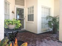 Inviting front porch with brick flooring, potted plants, and a charming entrance door at 14840 Shipwatch Trce # 1924, Largo, FL 33774