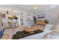 Bright living room featuring hardwood floors, stylish decor, and a smooth transition to the dining area at 1579 Bayshore Blvd, Dunedin, FL 34698