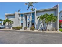 Condo exterior with blue accents, palm trees, and well-maintained landscaping for a tropical feel at 230 Medallion Blvd # F, Madeira Beach, FL 33708