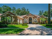 Charming home featuring a well-manicured lawn, inviting entrance, and a neatly paved driveway at 2417 Valrico Forest Dr, Valrico, FL 33594