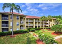 Well maintained condo complex with lush landscaping, benches, and palm trees offering a relaxing environment at 2690 Coral Landings Blvd # 217, Palm Harbor, FL 34684