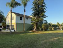 Two-story home with light siding, mature trees, and lawn at 3338 Fernleaf Dr, Hernando Beach, FL 34607
