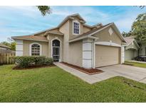 Charming two-story home featuring a two-car garage, landscaped yard, and inviting front entrance at 4228 Savage Station Cir, New Port Richey, FL 34653