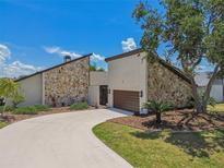 Striking stone accents and lush landscaping enhance this home's unique architecture with a winding driveway at 6119 Galleon Way, Tampa, FL 33615