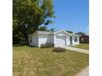 Charming one-story home with a well-maintained lawn and a one-car garage, under a clear blue sky at 10031 Cherry Creek Ln, Port Richey, FL 34668