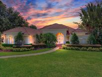 Stunning home with a tile roof and lush landscaping during a colorful sunset at 10504 Echo Lake Dr, Odessa, FL 33556