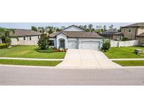 Charming single-story home with a well-maintained lawn and spacious driveway leading to a two-car garage at 18827 Henequen Lane, Spring Hill, FL 34610