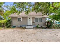 Charming single-story home featuring a simple front facade with grey paint, complemented by the surrounding lush greenery at 2038 16Th S St, St Petersburg, FL 33705