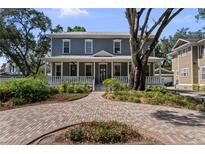 Charming two-story home featuring a brick driveway, welcoming front porch, and manicured landscaping at 2603 Sanders Dr, Tampa, FL 33611