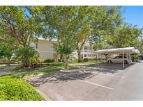 Beautiful two-story home with a white roof, lush landscaping, and covered parking spaces for convenient vehicle storage at 3702 54Th W Dr # 104, Bradenton, FL 34210
