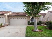 Charming home featuring a well-manicured lawn and a spacious two-car garage, complemented by a stylish red-tiled roof at 3875 Darston St, Palm Harbor, FL 34685