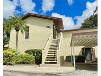 Charming condo featuring well-maintained landscaping, a carport, and an inviting entrance staircase at 501 E Bay Dr # 3504, Largo, FL 33770