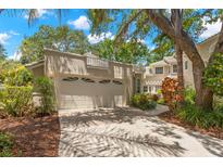 Exterior view showcasing a two-car garage, mature landscaping, and a well-maintained driveway at 5102 White Pine Ne Cir, St Petersburg, FL 33703