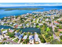 Panoramic aerial view of waterfront home with solar panels, dock, and lush landscaping on a sunny day at 5331 Bayou Grande Ne Blvd, St Petersburg, FL 33703