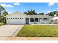 Charming single-story home featuring a well-manicured lawn, attached garage, and white exterior at 6006 114Th N Ter, Pinellas Park, FL 33782