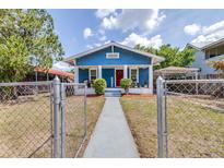 Charming blue craftsman-style home with a red door, white trim, and front porch at 910 E Chelsea St, Tampa, FL 33603