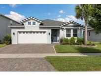 Charming single-story home with a two-car garage, paver driveway, and well-maintained lawn at 2401 Morninglight Dr, Lutz, FL 33558
