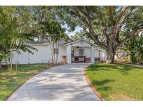 Charming home with a long driveway and beautiful mature trees creating a welcoming entrance at 3310 W Ballast Point Blvd, Tampa, FL 33611