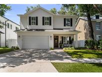 Charming two-story white brick home with black shutters, a manicured lawn, and an attached two-car garage at 3809 W San Pedro St, Tampa, FL 33629