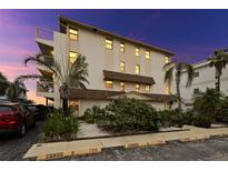 Three-story condo building with tropical landscaping and assigned parking spaces at 479 E Shore Dr # 5, Clearwater, FL 33767