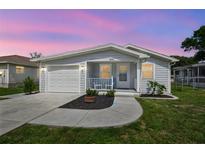 Charming home featuring a one-car garage, quaint porch with seating, and a well-manicured lawn at 4802 18Th St, Zephyrhills, FL 33542