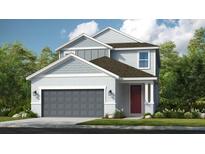 Charming two-story home featuring a gray garage door and a welcoming red front door at 727 Steel Dr, Apollo Beach, FL 33572