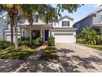 Charming two-story home featuring a well-manicured lawn, bright blue front door, and a two-car garage at 7309 S Shamrock Rd, Tampa, FL 33616
