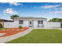 Charming single-story home with freshly manicured lawn, inviting entryway, and white picket fence at 812 60Th S St, Gulfport, FL 33707
