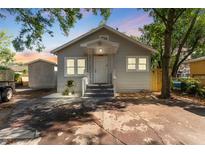 Charming single-story home with a covered entryway, gray exterior, and well-maintained front yard at 918 E 24Th Ave, Tampa, FL 33605